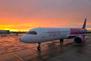 Ein Flugzeug der Fluggesellschaft Wizz Air steht im Sonnenuntergang auf dem Vorfeld des Dortmunder Flughafens