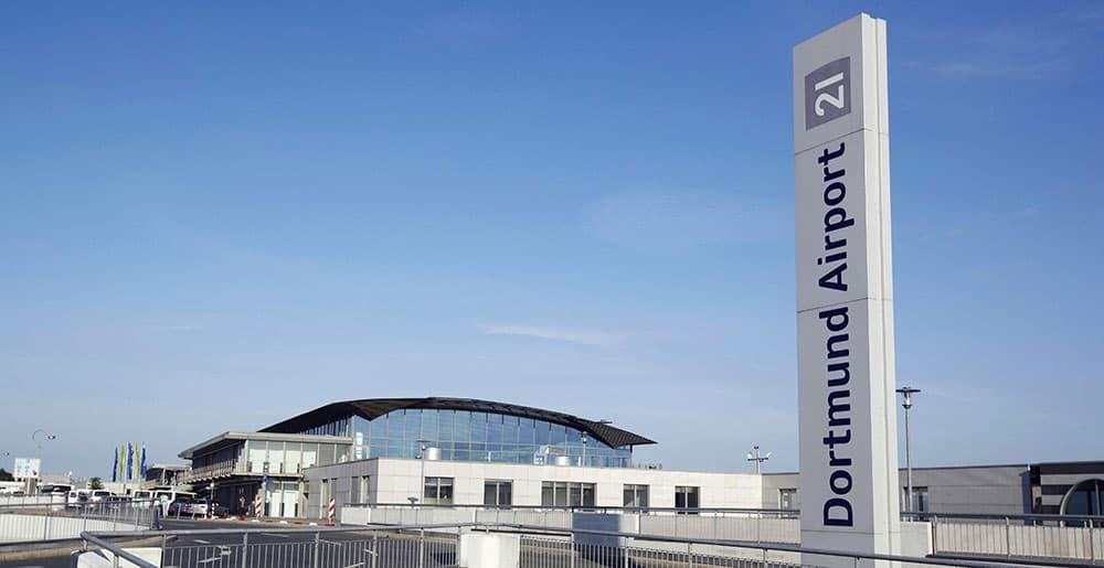 Stele mit Logo und Terminal des Dortmund Airport