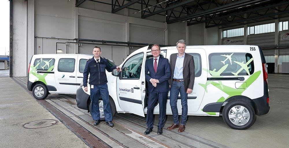 Flughafen-Geschäftsführer Udo Mager (Mitte), Prokurist Dietmar Krohne (rechts) und Jürgen Tautz, Leiter Fuhrparkmanagement (links) präsentieren die neuen E-Autos am Dortmund Airport 