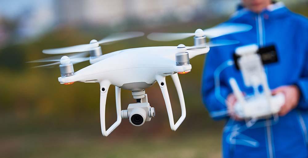 Ein Mann lässt eine Drohne fliegen.