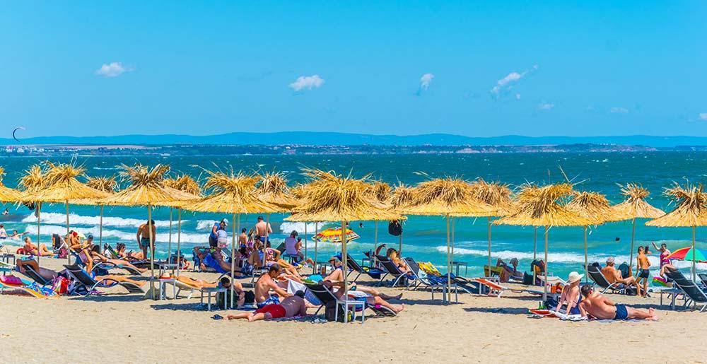 Urlauber genießen einen sonnigen Tag am Strand von Burgas in Bulgarien.