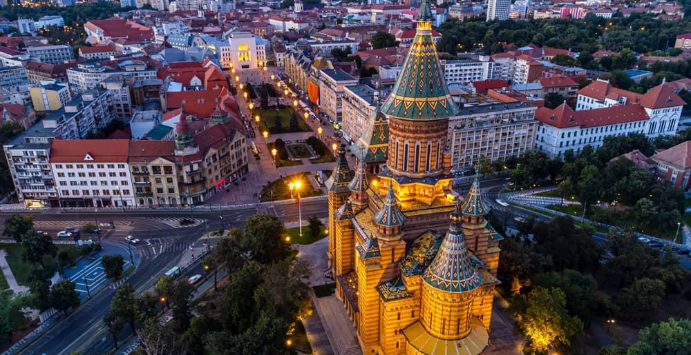 Luftaufnahme der orthodoxen Kathedrale von Timisoara und dem beleuchteten Stadtzentrum.
