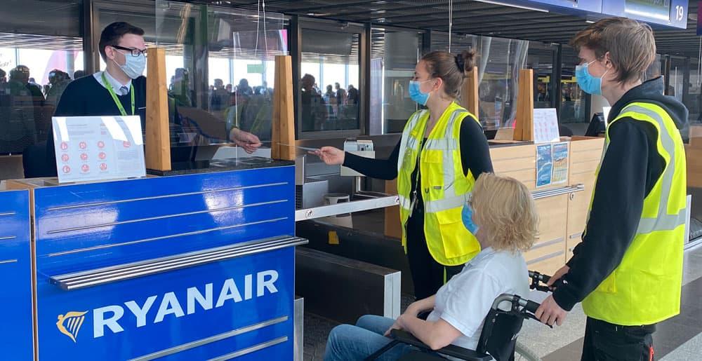 PRM-Service checkt Kunden am Check-In-Schalter von Ryanair ein. 
