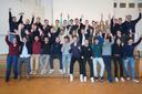 viele junge Menschen reißen jubelnd die Hände in die Luft 