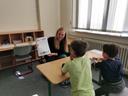Eine Studentin hilft Kindern beim Lesen