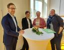 ein mann und drei frauen am stehtisch