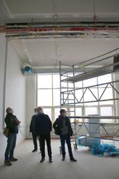 Männer schauen an die Decke auf einer Baustelle 