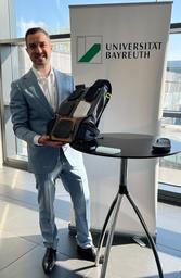 Dr.-Ing. Tobias Rosnitschek mit dem MonoMat-Demo Rucksack auf dem Lightweighting Summit.