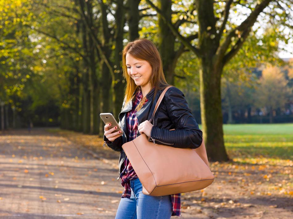 Frau mit Handy im Park