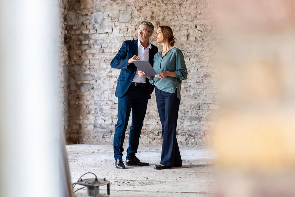 Mann und Frau besichtigen eine Baustelle