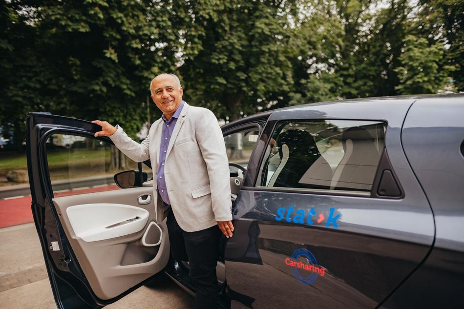 Mann öffnet die Tür des Carsharing Stadtteilautos