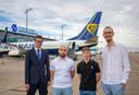 Vier Männer stehen vor einem Ryanair-Flugzeug am Albrecht Dürer Airport Nürnberg. Das Flugzeug steht auf dem Rollfeld mit ausgefahrener Einstiegstreppe. Im Hintergrund sind ein Schild mit der Aufschrift ‚Albrecht Dürer Airport Nürnberg‘ sowie Teile der Flughafeninfrastruktur zu sehen. Der Himmel ist leicht bewölkt.