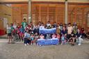 Große Gruppe von Kindern und Erwachsenen posiert vor einem Schulgebäude mit Bannern eines Schulprojekts in Peru.