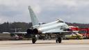 Eurofighter der Luftwaffe rollt auf dem Vorfeld des Flughafens Nürnberg, im Hintergrund stehen Einsatzfahrzeuge des Airports.