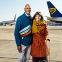 Die Testimonilas stehen bei Sonnenschein auf dem Vorfeld und lachen in die Kamera. Im Hintergrund stehen mehrere Flugzeuge.