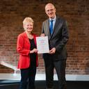 Birgit Uhlworm nimmt von Staatssekretär Michael Brand die Auszeichnung für das Bündnis für Familie Königs Wusterhausen entgegen. 