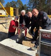 Sie versenken gemeinsam die Zeitkapsel im Fundament (v.l.n.r.): Ortsvorsteher Volker  Born, Bürgermeisterin Michaela Wiezorek, Stadtwehrführer Lars Hengelhaupt und  Ortswehrführer Marcel Schust